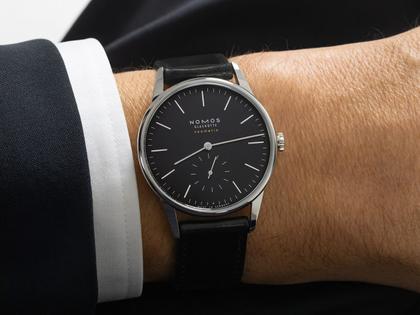 Nomos Glashütte Orion neomatik 39 New Black Automatik Edelstahl 39mm schwarzes Zifferblatt schwarzes Lederband Glasboden – Herrenuhren Uhr ohne Datum aus Edelstahl, Leder und rhodiniert. Das Gehäuse ist rund und silber. Das Lederarmband ist schwarz. Das Zifferblatt ist ein Index in schwarz. – Ansicht 6