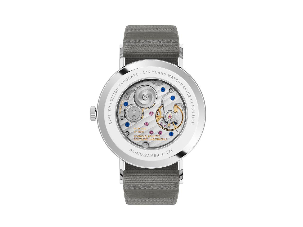 Nomos Glashütte Tangente 38 Datum "175 Years Watchmaking - Rambazamba" Handaufzug Edelstahl rotes Zifferblatt graues Textilband Glasboden – Herrenuhren Uhr mit Datum aus Edelstahl. Das Gehäuse ist rund und silber. Das Textilarmband ist grau. Das Zifferblatt ist arabisch Index und rot. – Ansicht 2