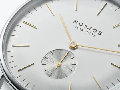 Nomos Glashütte Orion 38 Silber Handaufzug Edelstahl 38mm silberfarbenes Zifferblatt braunes Lederband Glasboden – Herrenuhren Uhr ohne Datum aus Edelstahl. Das Gehäuse ist rund und silber. Das Lederarmband ist grau. Das Zifferblatt ist ein Index in silber. – Ansicht 2