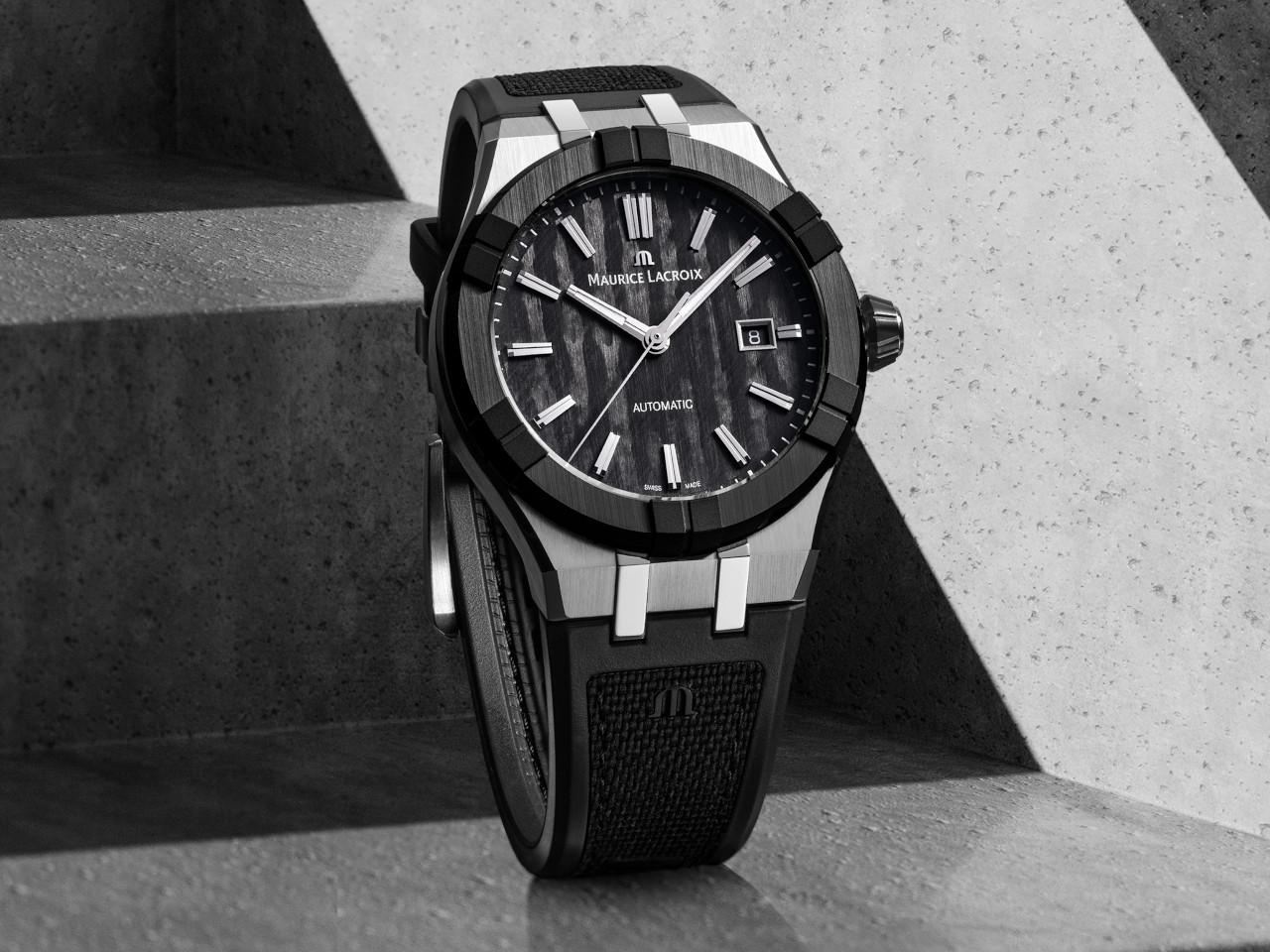 Maurice Lacroix AIKON-IC Automatik Edelstahl 43mm Carbon-Zifferblatt schwarzes Kautschukband – Herrenuhren Uhr mit Datum aus Carbon, Edelstahl, Kautschuk, Keramik und Leder. Das Gehäuse ist rund und silber. Das Kautschuk / Kunststoff / Silikon Armband ist schwarz. Das Zifferblatt ist ein Index in schwarz. – Ansicht 2