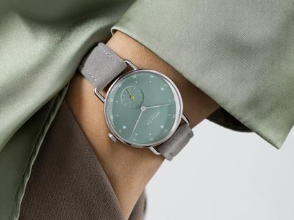 Nomos Glashütte Metro 33 Sage Handaufzug Edelstahl 33mm grünes Zifferblatt graues Lederband Stahlboden – Damenuhren Uhr ohne Datum aus Edelstahl und Leder. Das Gehäuse ist rund und silber. Das Lederarmband ist grau. Das Zifferblatt ist ein Index in grün. – Ansicht 4