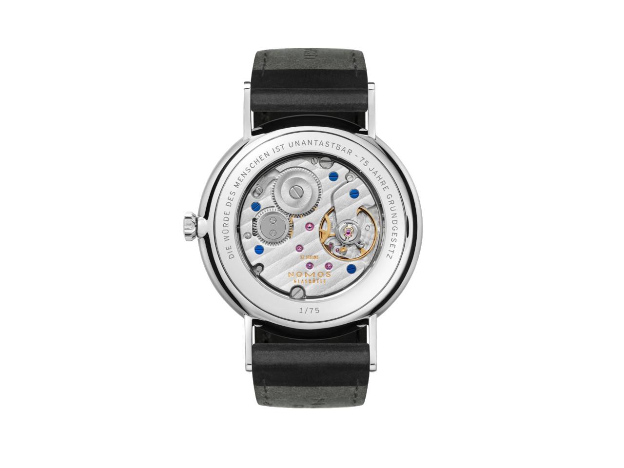 Nomos Glashütte Ludwig 38 75 Jahre Grundgesetz Handaufzug Edelstahl 38mm weißes Zifferblatt schwarzes Lederband limitiert – Herrenuhren Uhr ohne Datum aus Edelstahl und Leder. Das Gehäuse ist rund und silber. Das Lederarmband ist schwarz. Das Zifferblatt ist römisch Index und weiß. – Ansicht 2
