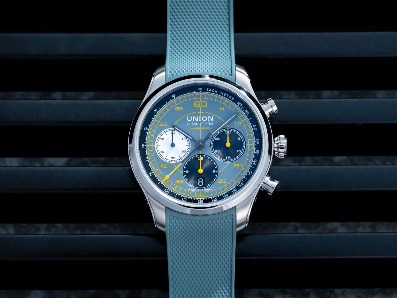Union Glashütte Belisar Chronograph Speedster 2025 Limited Edition Automatik Edelstahl 44mm blaues Zifferblatt blaues Kautschukband – Herrenuhren Chronograph aus Edelstahl und Kautschuk. Das Gehäuse ist rund und silber. Das Kautschuk / Kunststoff / Silikon Armband ist blau. Das Zifferblatt ist arabisch und blau. – Ansicht 5