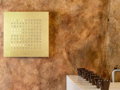Qlocktwo Earth 90 Creator's Edition Gold mit weiß lackiertem Holz – Großuhren Wanduhr aus Edelstahl. Das Gehäuse ist quadratisch. Das Zifferblatt ist digital und gelbgold. – Ansicht 3