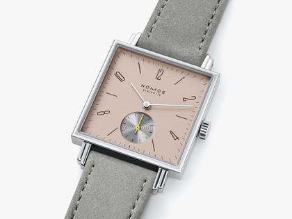 Nomos Glashütte Tetra Die Kapriziöse Handaufzug Edelstahl 29mm beiges Zifferblatt graues Veloursband Glasboden – Damenuhren Uhr ohne Datum aus Edelstahl und Leder. Das Gehäuse ist quadratisch und silber. Das Lederarmband ist grau. Das Zifferblatt ist arabisch Index und beige. – Ansicht 3