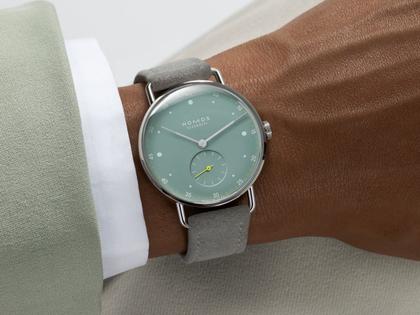 Nomos Glashütte Metro 33 Sage Handaufzug Edelstahl 33mm grünes Zifferblatt graues Lederband Glasboden – Damenuhren Uhr ohne Datum aus Edelstahl und Leder. Das Gehäuse ist rund und silber. Das Lederarmband ist grau. Das Zifferblatt ist ein Index in grün. – Ansicht 4