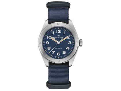 Herrenuhren Uhr ohne Datum aus Edelstahl. Das Gehäuse ist rund und silber. Das Textilarmband ist blau. Das Zifferblatt ist ein Index in blau.