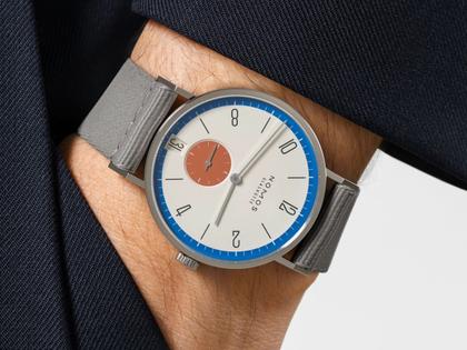 Nomos Glashütte Tangente 38 Datum "175 Years Watchmaking - Zirkus" Handaufzug Edelstahl cremeweißes Zifferblatt graues Textilband Glasboden – Herrenuhren Uhr mit Datum aus Edelstahl. Das Gehäuse ist rund und silber. Das Textilarmband ist grau. Das Zifferblatt ist arabisch Index und beige. – Ansicht 7