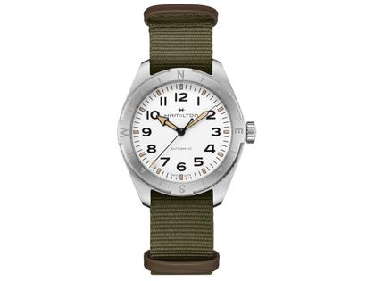 Herrenuhren Uhr ohne Datum aus Edelstahl. Das Gehäuse ist rund und silber. Das Textilarmband ist grün. Das Zifferblatt ist ein Index in weiß.