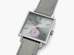 Nomos Glashütte Tetra Die Unerreichbare Handaufzug Edelstahl 29mm silberfarbenes Zifferblatt graues Veloursband Glasboden – Damenuhren Uhr ohne Datum aus Edelstahl und Leder. Das Gehäuse ist quadratisch und silber. Das Lederarmband ist grau. Das Zifferblatt ist arabisch Index und silber. – Ansicht 3