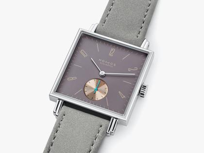 Nomos Glashütte Tetra Die Fuchsteufelswilde Handaufzug Edelstahl 29mm violettes Zifferblatt graues Veloursband Glasboden – Damenuhren Uhr ohne Datum aus Edelstahl und Leder. Das Gehäuse ist quadratisch und silber. Das Lederarmband ist grau. Das Zifferblatt ist arabisch Index und lila. – Ansicht 3