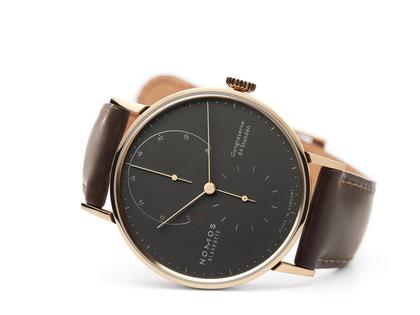 Nomos Glashütte Lambda 39 Samtschwarz Handaufzug Roségold 39mm schwarzes Zifferblatt braunes Lederband – Herrenuhren Uhr ohne Datum aus 750 Rotgold und Leder. Das Gehäuse ist rund und roségold. Das Lederarmband ist braun. Das Zifferblatt ist ein Index in schwarz. – Ansicht 3