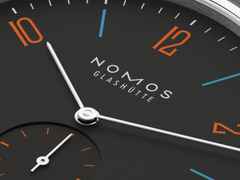 Nomos Glashütte Tangente 38 Datum "175 Years Watchmaking - Dunkelbunt" Handaufzug Edelstahl schwarzes Zifferblatt graues Textilband Glasboden – Herrenuhren Uhr mit Datum aus Edelstahl. Das Gehäuse ist rund und silber. Das Textilarmband ist grau. Das Zifferblatt ist arabisch Index und schwarz. – Ansicht 5