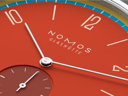 Nomos Glashütte Tangente 38 Datum "175 Years Watchmaking - Sportbunt" Handaufzug Edelstahl rotes Zifferblatt graues Textilband Glasboden – Herrenuhren Uhr mit Datum aus Edelstahl. Das Gehäuse ist rund und silber. Das Textilarmband ist grau. Das Zifferblatt ist arabisch Index und rot. – Ansicht 5