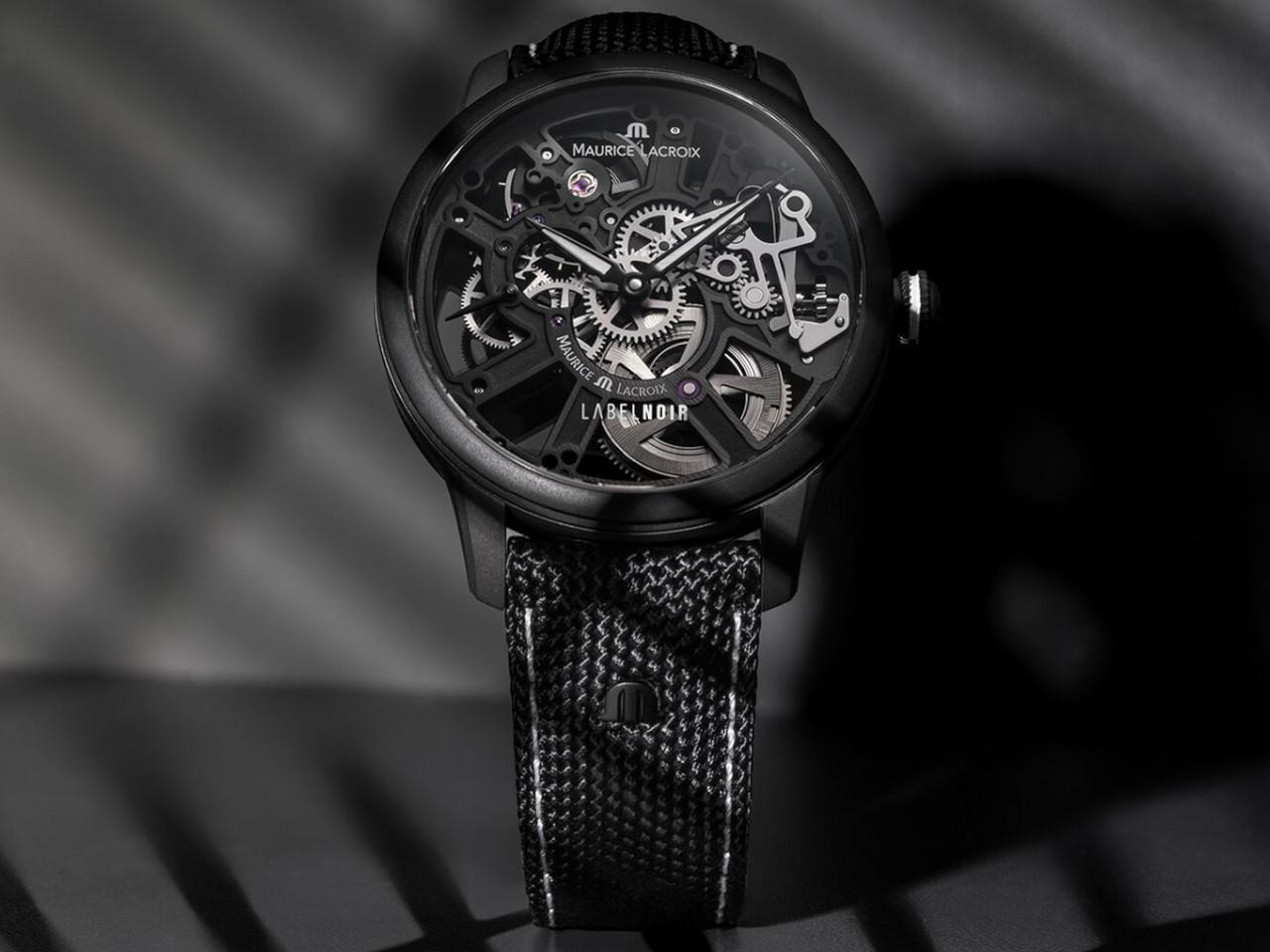 Maurice Lacroix Masterpiece Skeleton Label Noir Handaufzug Edelstahl Schwarz-DLC 43mm schwarzes Zifferblatt schwarzes Textilband – Herrenuhren Uhr ohne Datum aus DLC beschichtet, Edelstahl und PVD beschichtet. Das Gehäuse ist rund und schwarz. Das Textilarmband ist schwarz. Das Zifferblatt ist skelettiert und schwarz. – Ansicht 2