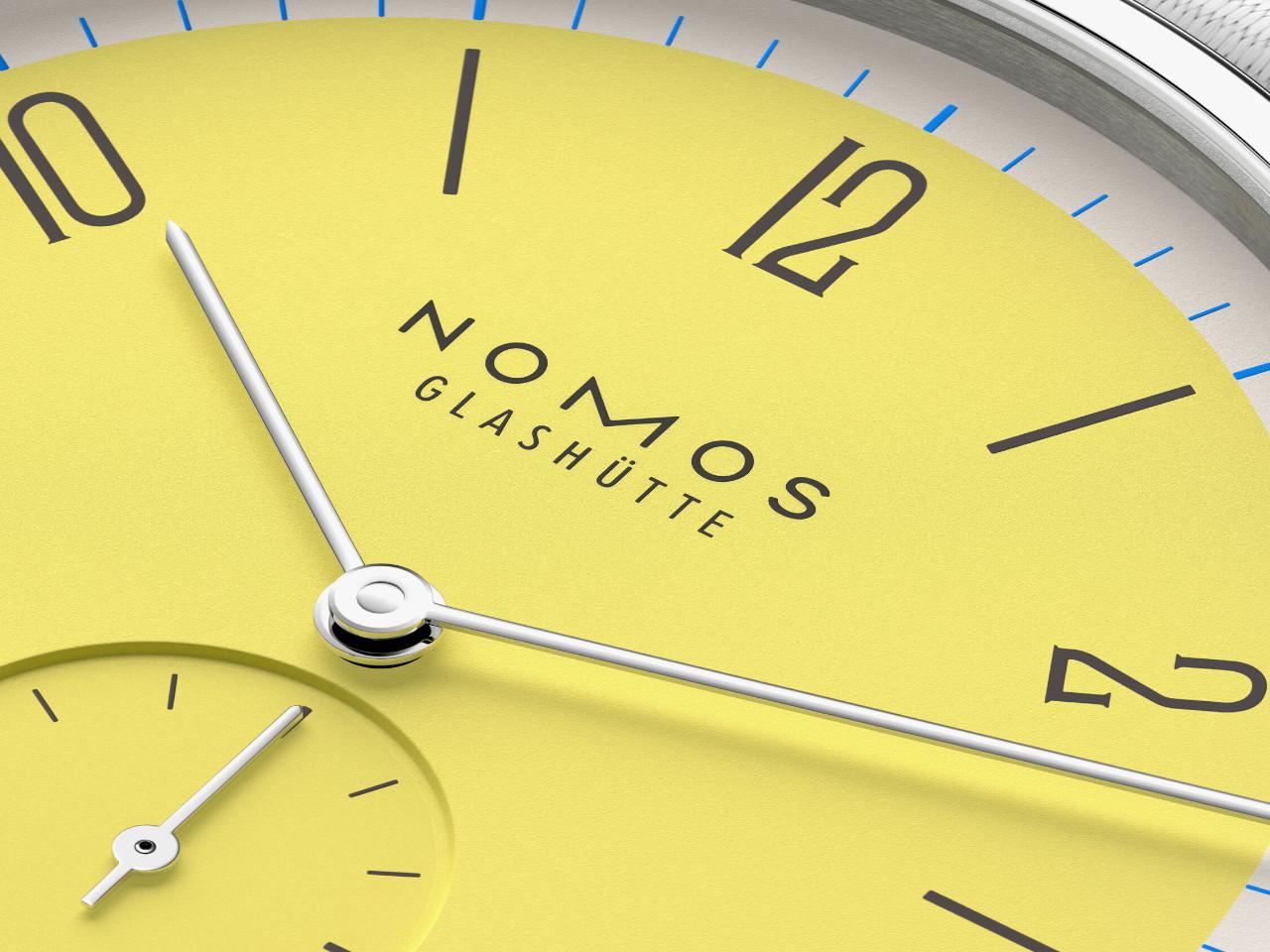 Nomos Glashütte Tangente 38 Datum "175 Years Watchmaking - Kanari" Handaufzug Edelstahl gelbes Zifferblatt graues Textilband Glasboden – Herrenuhren Uhr mit Datum aus Edelstahl. Das Gehäuse ist rund und silber. Das Textilarmband ist grau. Das Zifferblatt ist arabisch Index und gelb. – Ansicht 5
