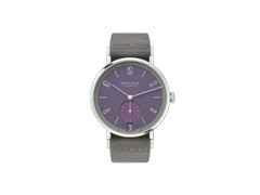 Nomos Glashütte Tangente 38 Datum "175 Years Watchmaking - Mauvegrün" Handaufzug Edelstahl violettes Zifferblatt graues Textilband Glasboden – Herrenuhren Uhr mit Datum aus Edelstahl. Das Gehäuse ist rund und silber. Das Textilarmband ist grau. Das Zifferblatt ist arabisch Index und lila.