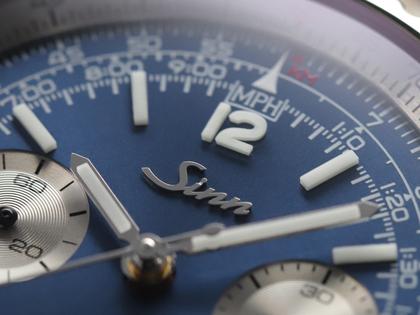 Sinn Spezialuhren 903 Ti II Jubiläum Navigationschronograph Automatik Titan 41mm blaues Zifferblatt braunes Lederband und Titanband limitiert – Herrenuhren Chronograph aus Titan. Das Gehäuse ist rund und grau. Das Lederarmband ist braun. Das Zifferblatt ist arabisch Index und blau. – Ansicht 7