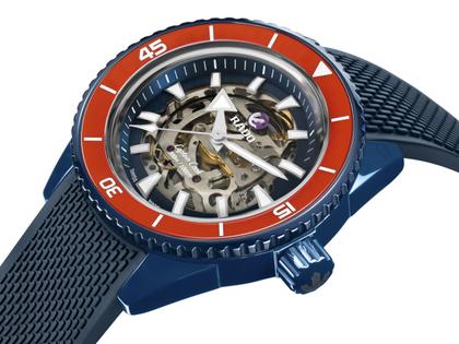 Rado Captain Cook High-Tech Ceramic Skeleton Limited Edition Orange Automatik Keramik 43mm skelettiertes Zifferblatt blaues Kautschukband – Herrenuhren Uhr ohne Datum aus Edelstahl, Kautschuk, Keramik, PVD beschichtet und Titan. Das Gehäuse ist rund und blau. Das Kautschuk / Kunststoff / Silikon Armband ist blau. Das Zifferblatt ist ein Index in grau. – Ansicht 2