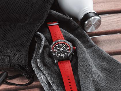 Breitling Endurance Pro 44 Chronograph Quarz Breitlight schwarzes Zifferblatt rotes Kautschukband – Herrenuhren Chronograph aus Sonstiges. Das Gehäuse ist rund und schwarz. Das Kautschuk / Kunststoff / Silikon Armband ist rot. Das Zifferblatt ist arabisch und schwarz. – Ansicht 3