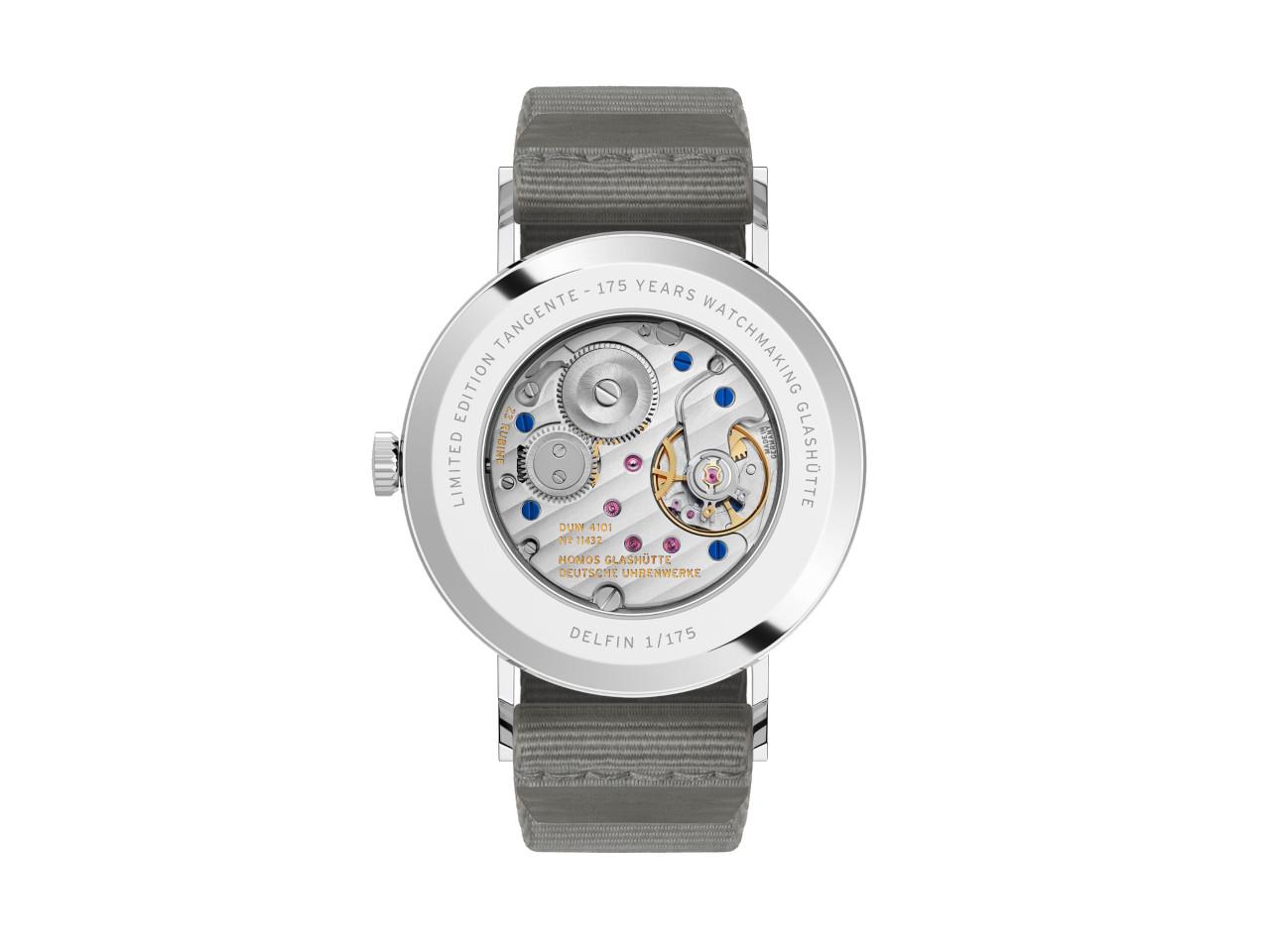 Nomos Glashütte Tangente 38 Datum "175 Years Watchmaking - Delfin" Handaufzug Edelstahl blaues Zifferblatt graues Textilband Glasboden – Herrenuhren Uhr mit Datum aus Edelstahl. Das Gehäuse ist rund und silber. Das Textilarmband ist grau. Das Zifferblatt ist arabisch Index und blau. – Ansicht 2