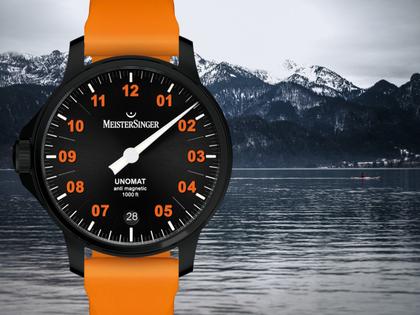 MeisterSinger Unomat Automatik Edelstahl 43mm schwarzes Zifferblatt orangefarbenes Kautschukband limitiert – Herrenuhren Uhr mit Datum aus DLC beschichtet, Edelstahl und Kautschuk. Das Gehäuse ist rund und schwarz. Das Kautschuk / Kunststoff / Silikon Armband ist orange. Das Zifferblatt ist arabisch Index und schwarz. – Ansicht 2