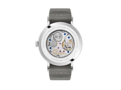 Nomos Glashütte Tangente 38 Datum "175 Years Watchmaking - Dunkelbunt" Handaufzug Edelstahl schwarzes Zifferblatt graues Textilband Glasboden – Herrenuhren Uhr mit Datum aus Edelstahl. Das Gehäuse ist rund und silber. Das Textilarmband ist grau. Das Zifferblatt ist arabisch Index und schwarz. – Ansicht 2
