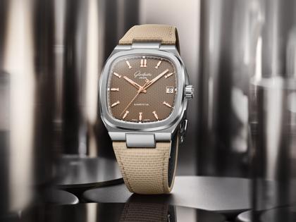 Glashütte Original Seventies Vintage Kollektion Tweed Amp Automatik Edelstahl 39x39mm beiges Zifferblatt beiges Kautschukband – Herrenuhren Uhr mit Datum aus 750 Rotgold, Edelstahl und Kautschuk. Das Gehäuse ist quadratisch und silber. Das Kautschuk / Kunststoff / Silikon Armband ist beige. Das Zifferblatt ist ein Index in beige. – Ansicht 7