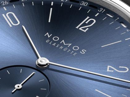 Nomos Glashütte Tangente 2date Handaufzug Edelstahl 38mm blaues Zifferblatt schwarzes Lederband Glasboden – Herrenuhren Uhr mit Datum aus Edelstahl und Leder. Das Gehäuse ist rund und silber. Das Lederarmband ist schwarz. Das Zifferblatt ist arabisch Index und blau. – Ansicht 7