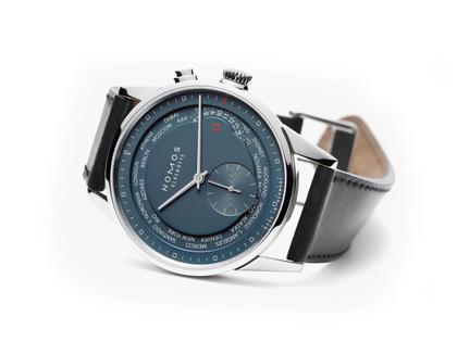 Nomos Glashütte Zürich Weltzeit Nachtblau Automatik Edelstahl 40mm weißes Zifferblatt schwarzes Lederband – Herrenuhren Uhr ohne Datum aus Edelstahl und Leder. Das Gehäuse ist rund und silber. Das Lederarmband ist schwarz. Das Zifferblatt ist ein Index in blau. – Ansicht 2