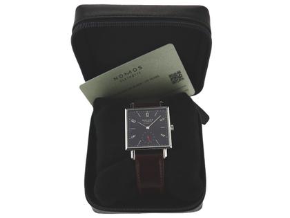 Nomos Glashütte Tetra "175 Years Watchmaking" Black Limited Edition Automatik Edelstahl 33x33mm 421.S4 Full Set Occasion Neu – Herrenuhren Uhr ohne Datum aus Edelstahl. Das Gehäuse ist quadratisch und silber. Das Lederarmband ist braun. Das Zifferblatt ist arabisch Index und schwarz. – Ansicht 3