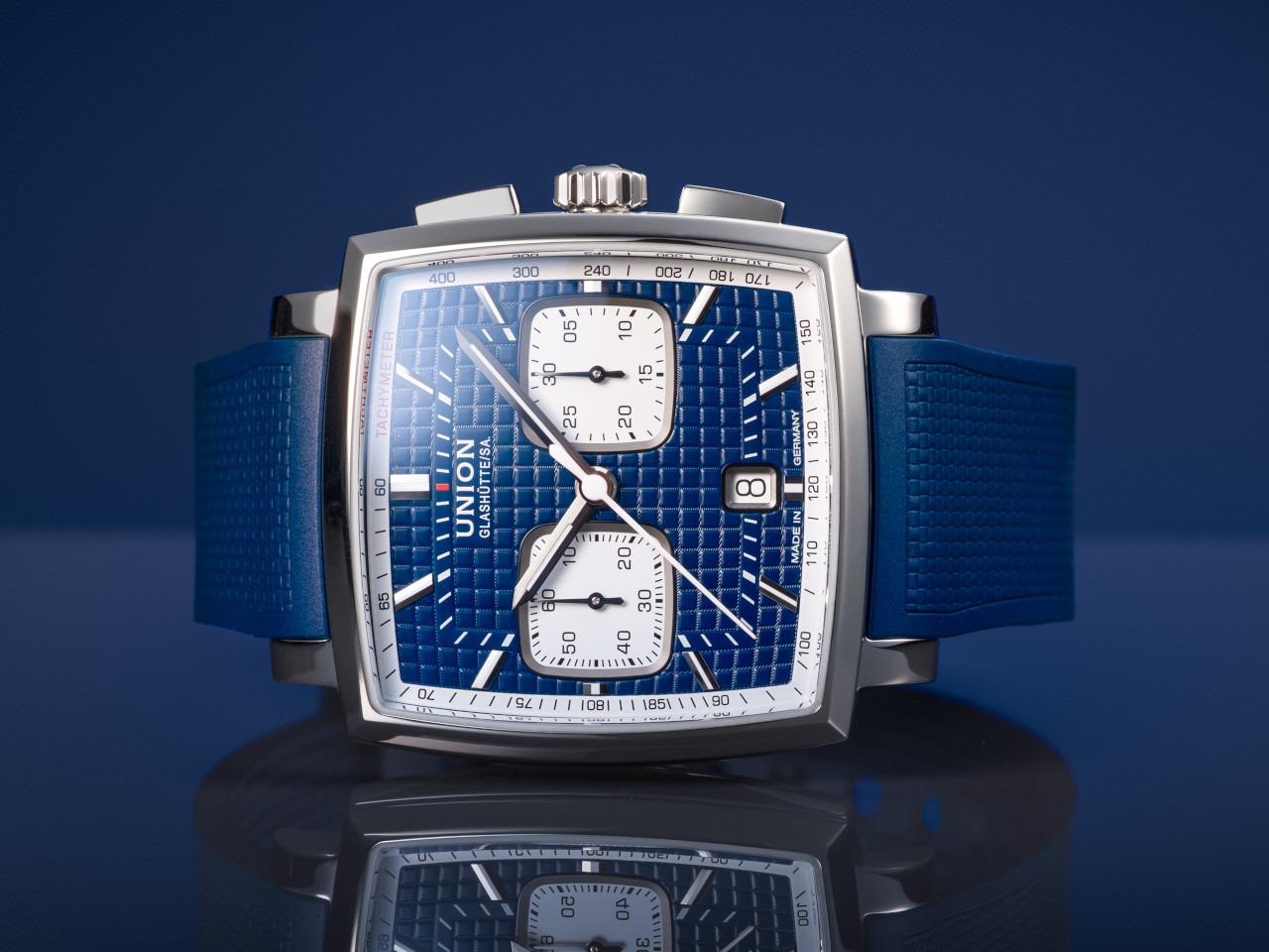 Union Glashütte Averin Chronograph Automatik Edelstahl 41mm blaues Zifferblatt blaues Kautschukband blaues Lederband – Herrenuhren Chronograph aus Edelstahl, Kautschuk und Leder. Das Gehäuse ist quadratisch und silber. Das Lederarmband ist grau. Das Zifferblatt ist ein Index in blau. – Ansicht 6