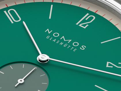 Nomos Glashütte Tangente 38 Datum "175 Years Watchmaking - Schlossgrün" Handaufzug Edelstahl grünes Zifferblatt graues Textilband Glasboden – Herrenuhren Uhr mit Datum aus Edelstahl. Das Gehäuse ist rund und silber. Das Textilarmband ist grau. Das Zifferblatt ist arabisch Index und grün. – Ansicht 5
