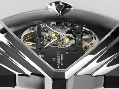 Hamilton Ventura XXL Skeleton Automatic Edelstahl 46x46mm skelettiertes Zifferblatt schwarzes Kautschukband – Herrenuhren Uhr ohne Datum aus Edelstahl und Kautschuk. Das Gehäuse ist sonstige Form und silber. Das Kautschuk / Kunststoff / Silikon Armband ist schwarz. Das Zifferblatt ist skelettiert und schwarz. – Ansicht 5