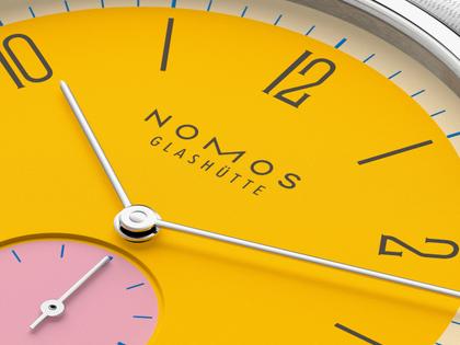 Nomos Glashütte Tangente 38 Datum "175 Years Watchmaking - Katzengold" Handaufzug Edelstahl gelbes Zifferblatt graues Textilband Glasboden – Herrenuhren Uhr mit Datum aus Edelstahl. Das Gehäuse ist rund und silber. Das Textilarmband ist grau. Das Zifferblatt ist arabisch Index und gelb. – Ansicht 6