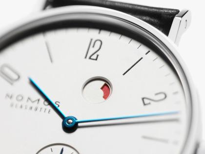 Nomos Glashütte Tangente 35 Datum Gangreserve Handaufzug Edelstahl 35mm weißes Zifferblatt schwarzes Lederband Glasboden – Herrenuhren Uhr mit Datum aus Edelstahl und Leder. Das Gehäuse ist rund und silber. Das Lederarmband ist schwarz. Das Zifferblatt ist arabisch Index und silber. – Ansicht 2