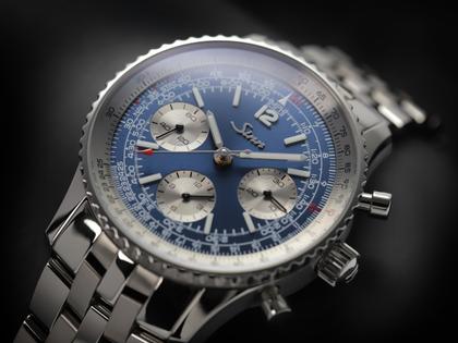 Sinn Spezialuhren 903 Ti II Jubiläum Navigationschronograph Automatik Titan 41mm blaues Zifferblatt braunes Lederband und Titanband limitiert – Herrenuhren Chronograph aus Titan. Das Gehäuse ist rund und grau. Das Lederarmband ist braun. Das Zifferblatt ist arabisch Index und blau. – Ansicht 8