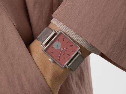 Nomos Glashütte Tetra Origins Terra Handaufzug Edelstahl 29,5mm rotes Zifferblatt graues Lederband Stahlboden – Damenuhren Uhr ohne Datum aus Edelstahl und Leder. Das Gehäuse ist quadratisch und silber. Das Lederarmband ist grau. Das Zifferblatt ist arabisch Index und rot. – Ansicht 9