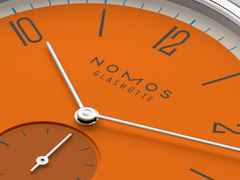 Nomos Glashütte Tangente 38 Datum "175 Years Watchmaking - Boje" Handaufzug Edelstahl orangenes Zifferblatt graues Textilband Glasboden – Herrenuhren Uhr mit Datum aus Edelstahl. Das Gehäuse ist rund und silber. Das Textilarmband ist grau. Das Zifferblatt ist arabisch Index und orange. – Ansicht 5