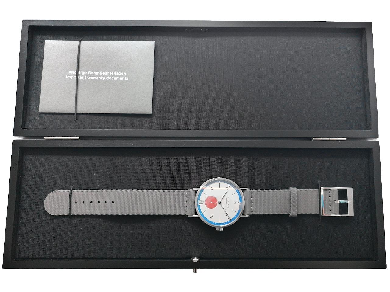 Nomos Glashütte Tangente 38 Datum "175 Years Watchmaking - Zirkus" Handaufzug Edelstahl cremeweißes Zifferblatt graues Textilband Glasboden 179.S1 Full Set Occasion Neu – Herrenuhren Uhr mit Datum aus Edelstahl. Das Gehäuse ist rund und silber. Das Textilarmband ist grau. Das Zifferblatt ist arabisch Index und weiß. – Ansicht 3