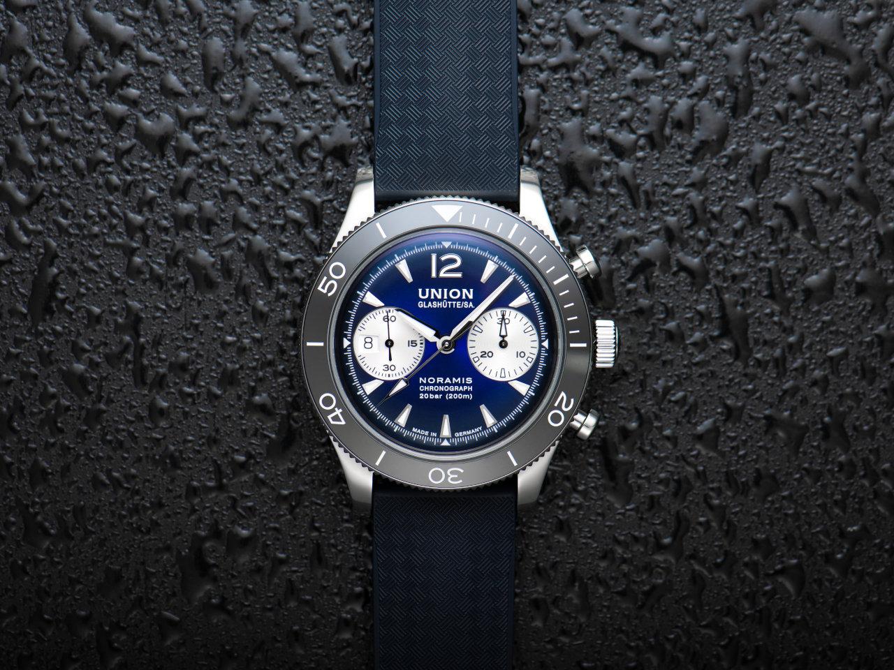 Union Glashütte Noramis Chronograph Sport Automatik Edelstahl 43mm blaues Zifferblatt blaues Kautschukband – Herrenuhren Chronograph aus Edelstahl, Kautschuk und Keramik. Das Gehäuse ist rund und silber. Das Kautschuk / Kunststoff / Silikon Armband ist blau. Das Zifferblatt ist arabisch Index und blau. – Ansicht 2