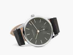 Nomos Glashütte Orion 33 1989 Handaufzug Edelstahl 33mm graues Zifferblatt schwarzes Lederband Glasboden – Damenuhren Uhr ohne Datum aus Edelstahl und Leder. Das Gehäuse ist rund und silber. Das Lederarmband ist anthrazit. Das Zifferblatt ist ein Index in anthrazit. – Ansicht 3
