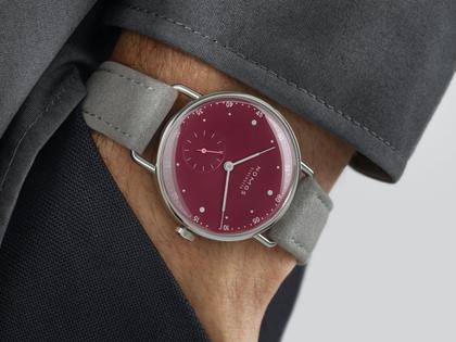Nomos Glashütte Metro 33 Muted Red Handaufzug Edelstahl 33mm rotes Zifferblatt graues Lederband Glasboden – Damenuhren Uhr ohne Datum aus Edelstahl und Leder. Das Gehäuse ist rund und silber. Das Lederarmband ist grau. Das Zifferblatt ist ein Index in rot. – Ansicht 4