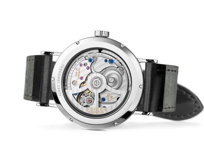 Nomos Glashütte Tangomat Automatik Edelstahl 38mm weißes Zifferblatt schwarzes Lederband Glasboden – Herrenuhren Uhr ohne Datum aus Edelstahl und Leder. Das Gehäuse ist rund und silber. Das Lederarmband ist schwarz. Das Zifferblatt ist arabisch Index und weiß. – Ansicht 5