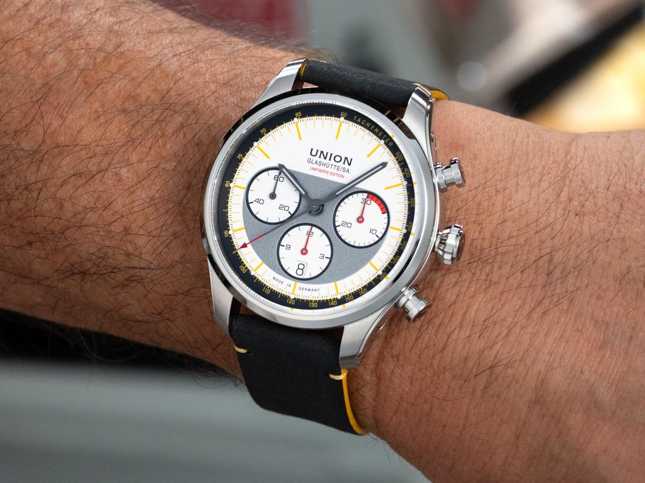 Union Glashütte Belisar Chronograph Silvretta Classic 2026 Limitierte Edition Automatik Edelstahl 44mm beiges Zifferblatt gelbes Textilband schwarzes Lederband und Metallband – Herrenuhren Chronograph aus Edelstahl und Leder. Das Gehäuse ist rund und silber. Das Textilarmband ist gelb. Das Zifferblatt ist ein Index in beige. – Ansicht 7