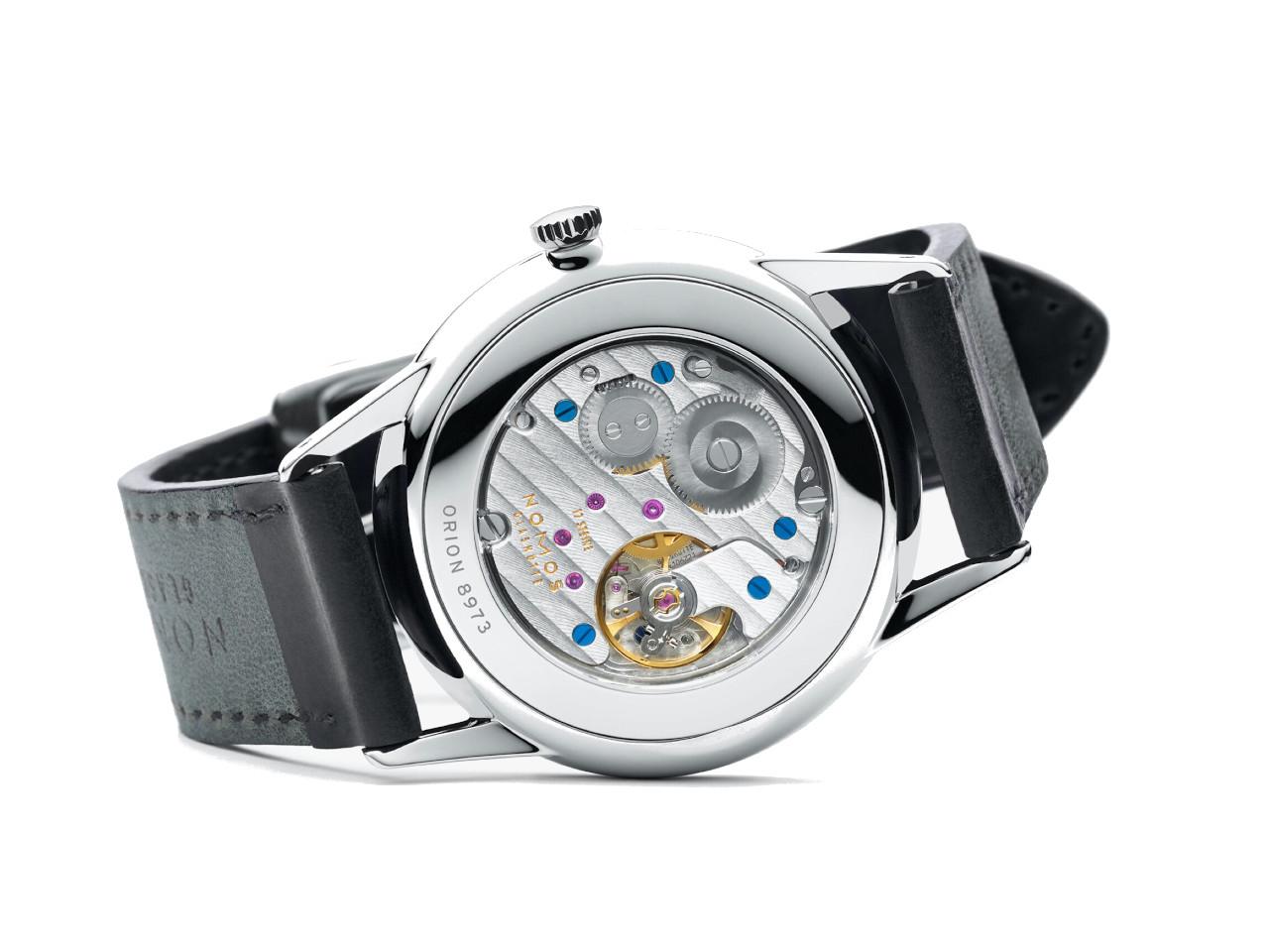 Nomos Glashütte Orion 38 Handaufzug Edelstahl 38mm weißes Zifferblatt schwarzes Zifferblatt Glasboden – Herrenuhren Uhr ohne Datum aus Edelstahl. Das Gehäuse ist rund und silber. Das Lederarmband ist schwarz. Das Zifferblatt ist ein Index in weiß. – Ansicht 4