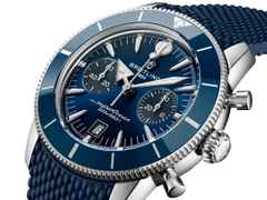 Breitling Superocean Heritage B01 Chronograph Automatik Edelstahl 42mm blaues Zifferblatt blaues Kautschukband – Herrenuhren Chronograph aus Edelstahl, Kautschuk und Keramik. Das Gehäuse ist rund und silber. Das Kautschuk / Kunststoff / Silikon Armband ist blau. Das Zifferblatt ist ein Index in blau. – Ansicht 2