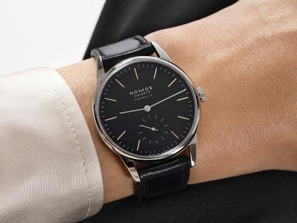 Nomos Glashütte Orion neomatik New Black Automatik Edelstahl 36mm schwarzes Zifferblatt schwarzes Lederband Glasboden – Herrenuhren Uhr ohne Datum aus Edelstahl und Leder. Das Gehäuse ist rund und silber. Das Lederarmband ist schwarz. Das Zifferblatt ist ein Index in schwarz. – Ansicht 6