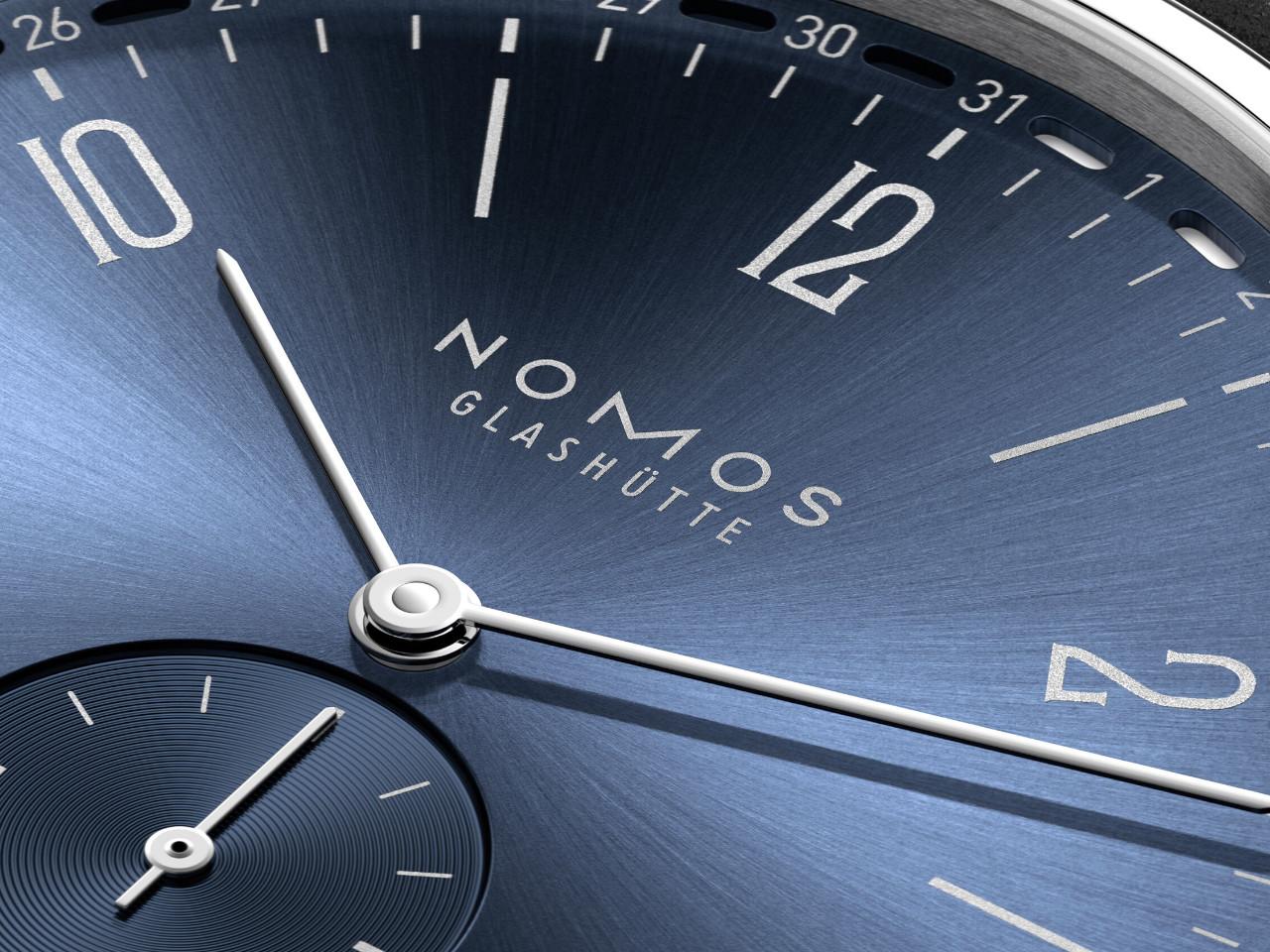 Nomos Glashütte Tangente 2date Handaufzug Edelstahl 38mm blaues Zifferblatt schwarzes Lederband Glasboden – Herrenuhren Uhr mit Datum aus Edelstahl und Leder. Das Gehäuse ist rund und silber. Das Lederarmband ist schwarz. Das Zifferblatt ist arabisch Index und blau. – Ansicht 7