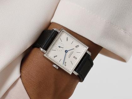 Nomos Glashütte Tetra 27 Weiss Handaufzug Edelstahl 27mm weißes Zifferblatt schwarzes Lederband Stahlboden – Damenuhren Uhr ohne Datum aus Edelstahl und Leder. Das Gehäuse ist quadratisch und silber. Das Lederarmband ist schwarz. Das Zifferblatt ist arabisch Index und weiß. – Ansicht 8